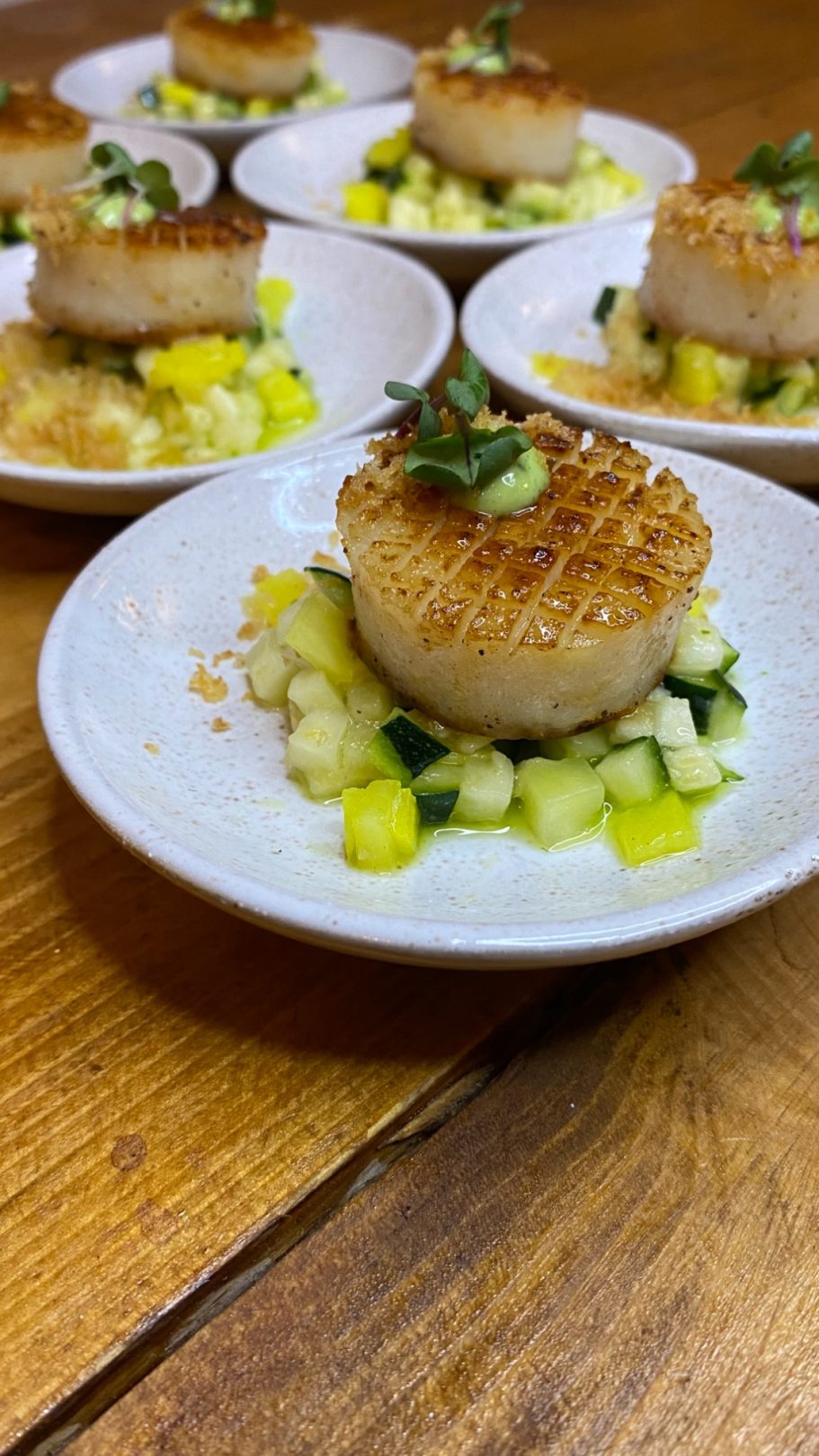 Gebratene Jakobsmuscheln auf Zucchini-Ananas-Salat mit Kräutern.